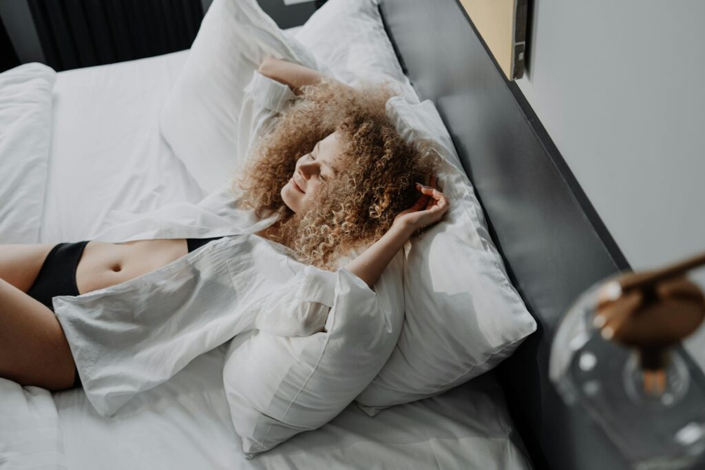 woman in white dress lying on bed