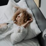 woman in white dress lying on bed